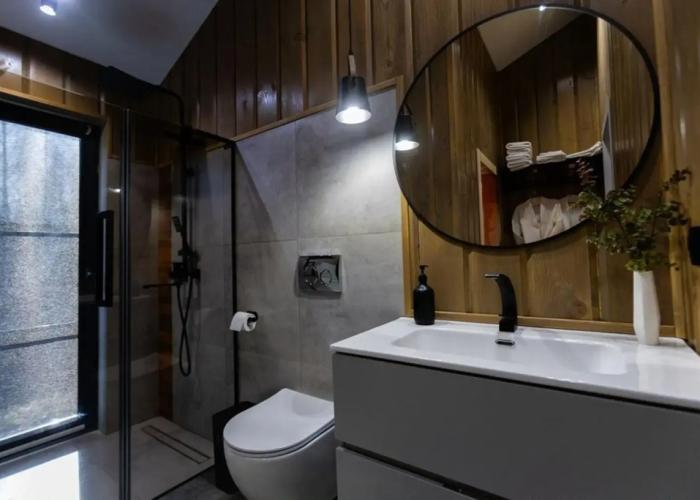 Panoramic house in a coniferous forest with sauna